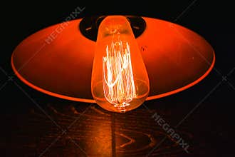 Red colored edison style lamp on a wall
