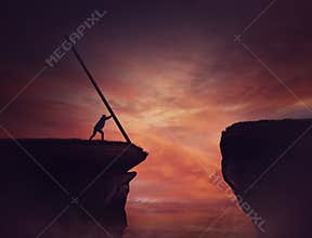 Businessman pushing a long beam, creating an improvised bridge to cross the abyss obstacle. Cover the gap and reach other side of