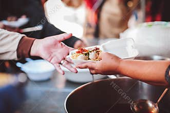 The poor reach out to receive donated food: Homeless people receive free charity food
