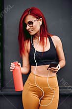 Beautiful athletic girl working out while listening to music, fitness concept