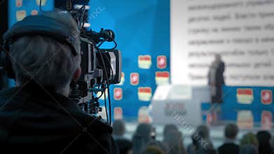 The cameraman makes video for television. Auditorium, seminar and lecture on business. Professional ideas, politics or