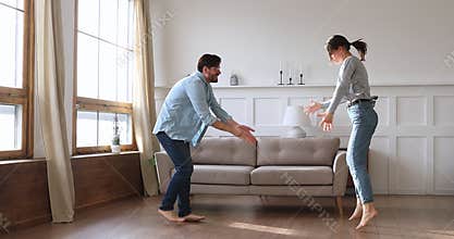 Happy carefree young couple dancing in living room together