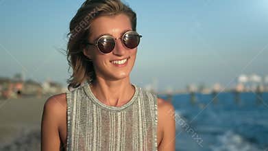 Closeup face of attractive tourist woman laughing relaxed at seascape background slowmo