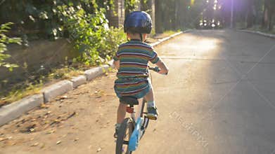 Kid with helmet on a bicycle on the road