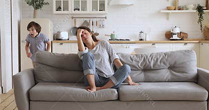 Tired upset young mother feel frustrated about active noisy kids