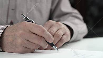 Wise old man in checkered shirt rereads letter and signs