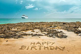 Hand written happy birthday on the beach
