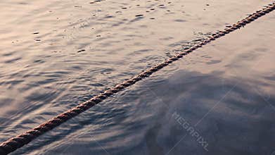 Ripples sea waves as water texture background and anchor rope