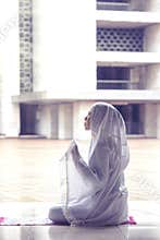 Young woman praying to Allah in the mosque