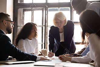 Diverse employees discuss financial business paperwork at briefing