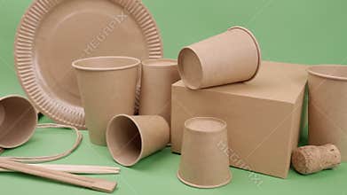 Tableware and packaging made of ecological materials on a green background.