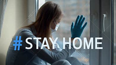 Hashtag stay home over woman looking out the window