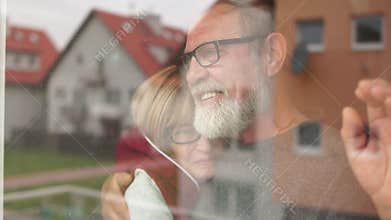 The old lonely family in quarantine looks out the window. Quarantine at home for coronavirus pandemic prevention. A man