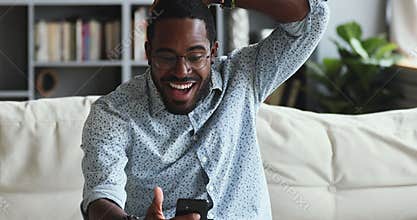 Excited young african ethnicity guy reading message with unbelievable news.