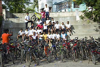 A group of young persons are relaxing after a bicycle ride