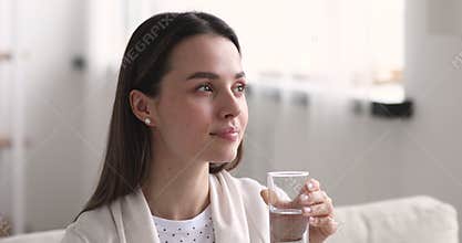 Attractive healthy young woman holding glass drinking fresh mineral water