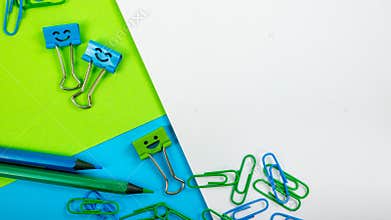 Colored Paper Clip, Smile Binder Clips and Pencils on Paper Notepad