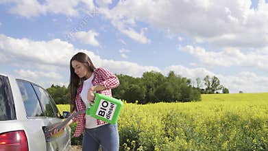 Young girl refuelling a car with bio diesel from green jerry can