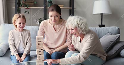 Little child involved in build game with mom and granny.