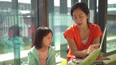 4K Slow motion of asian parent and child reading books at the library