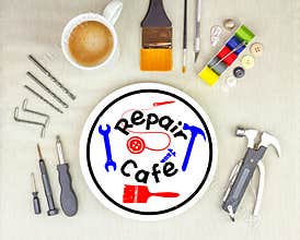 Repair Cafe logo on plate with a mug coffee surrounded by repair tools on table top, consumer activism