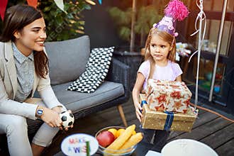 Birthday girl with gifts together with mom