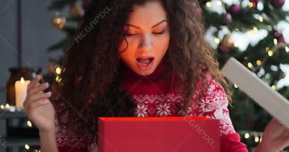 Excited woman opening surprise Christmas gift