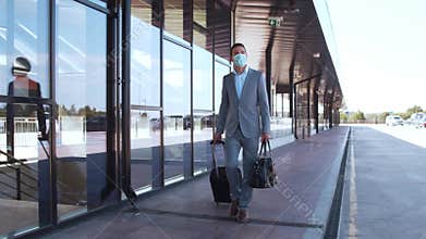Elegant businessman wearing protective mask in airport. Young mail entrepreneur in formalwear. Pandemic, new rules of