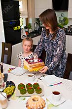 Mother bringing birthday cake for her lovely daughter