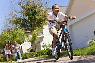 African American Boy Riding Bike & Happy Parents