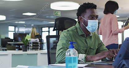Man wearing face mask using computer at office