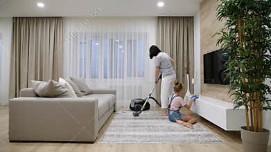 Preteen Daughter and mother cleaning their home`s living room, slow motion