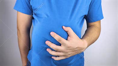 The man is holding onto his swollen belly. Bloating, flatulence, gas, malfunction of the gastrointestinal tract. Conceptual video
