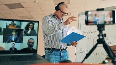 Male teacher is performing an online class for a group of adults. Online learning, online training, online education