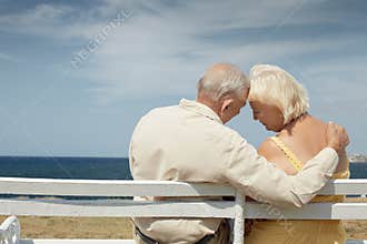 Old man and woman on bench at the sea