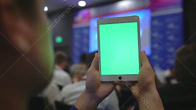 Key green screen tablet crowd audience business forum. Replace mockup record pad