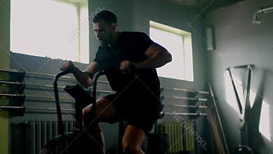 Fitness man train on exercise bike at gym .
