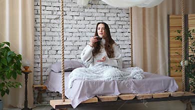 Young pretty woman drinking aroma coffee in bed at home