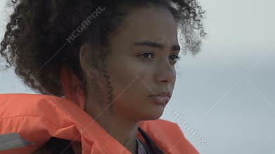 Upset black girl in life vest, surviving in dangerous situation, catastrophe