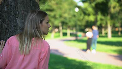 Woman spying loving couple walking on outdoor date, jealous ex-girlfriend