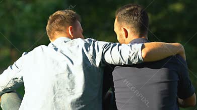Man hugging over shoulder his best friend, calming and supporting, friendship