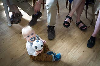 One year old boy with ball with adults