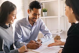 Salesmen are letting the male customers sign the sales contract, Asian women and couple are doing business in the office, Business
