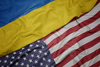 waving colorful flag of united states of america and national flag of ukraine. macro