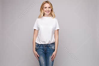Slim woman wearing white shirt and jeans standing steady
