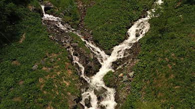 Aerial view. Turbulent streams coming down from mountains and flowing into river