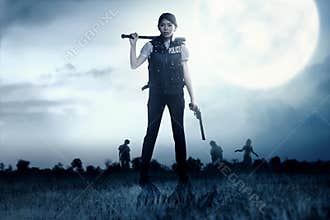 Asian policewoman with the gun and baseball bat in her hand face the zombies on the grass field