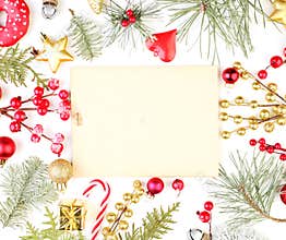 Christmas frame made of Xmas decorations and vintage paper card. Golden gift, star, red holly berries and green fir branch