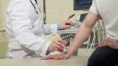 Man getting his wrist bones checked by doctor using ultrasound scanner