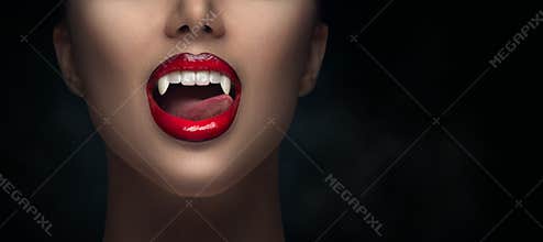 Sexy Vampire Woman`s red bloody lips close-up. Vampire girl licking fangs with tongue. Fashion Glamour Halloween art design